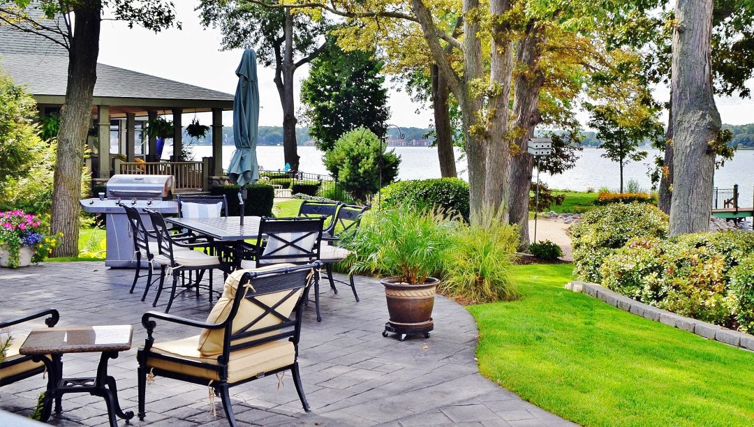 A Spokane Concrete patio and outdoor area with beautiful trees, landscaping, tables and chairs.